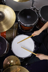Professional drum set closeup. Man drummer with drumsticks playing drums and cymbals, on the live...