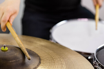 Professional drum set closeup. Man drummer with drumsticks playing drums and cymbals, on the live...