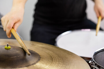Professional drum set closeup. Man drummer with drumsticks playing drums and cymbals, on the live...