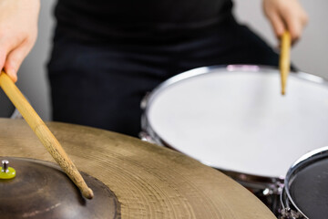 Professional drum set closeup. Man drummer with drumsticks playing drums and cymbals, on the live...