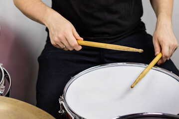 Professional drum set closeup. Man drummer with drumsticks playing drums and cymbals, on the live music rock concert or in recording studio   