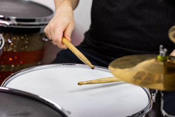 Professional drum set closeup. Man drummer with drumsticks playing drums and cymbals, on the live music rock concert or in recording studio   