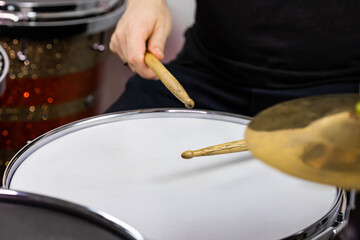 Professional drum set closeup. Man drummer with drumsticks playing drums and cymbals, on the live music rock concert or in recording studio   