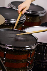Professional drum set closeup. Man drummer with drumsticks playing drums and cymbals, on the live...