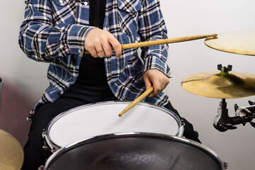 Professional drum set closeup. Man drummer with drumsticks playing drums and cymbals, on the live...