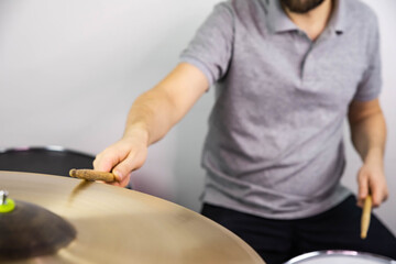 Professional drum set closeup. Man drummer with drumsticks playing drums and cymbals, on the live music rock concert or in recording studio   