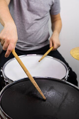 Professional drum set closeup. Man drummer with drumsticks playing drums and cymbals, on the live music rock concert or in recording studio   