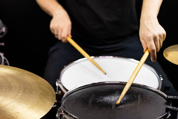Professional drum set closeup. Man drummer with drumsticks playing drums and cymbals, on the live...