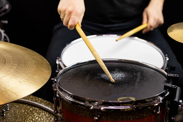 Professional drum set closeup. Man drummer with drumsticks playing drums and cymbals, on the live...