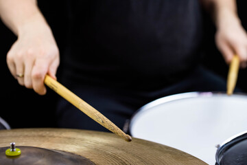 Professional drum set closeup. Man drummer with drumsticks playing drums and cymbals, on the live...