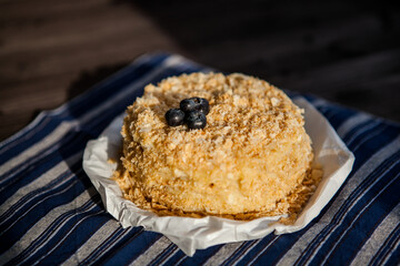 homemade cake decorated with crumbs and blueberries on a dark background