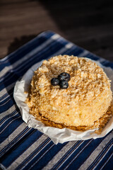 homemade cake decorated with crumbs and blueberries on a dark background