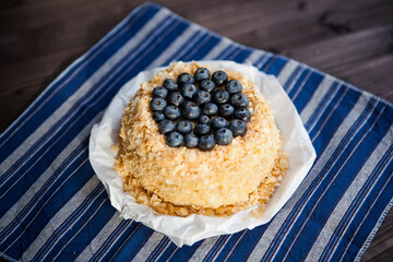 homemade cake decorated with crumbs and blueberries on a dark background
