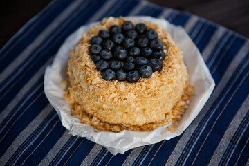 homemade cake decorated with crumbs and blueberries on a dark background