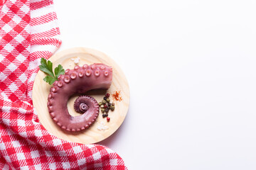stew octopus tentacles on wooden plate on white background with copy space, Top view.