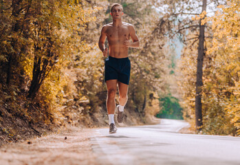 Running shirtless athlete man. Male runner sprinting during outdoors training on the mountain