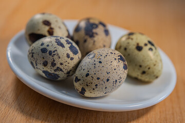 quail eggs in a plate stand on the table surface indoors.