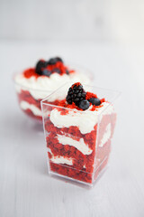 homemade portioned dessert red velvet decorated with berries on a light wooden background