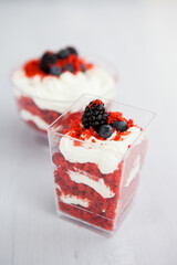 homemade portioned dessert red velvet decorated with berries on a light wooden background