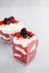 homemade portioned dessert red velvet decorated with berries on a light wooden background