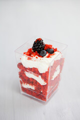 homemade portioned dessert red velvet decorated with berries on a light wooden background
