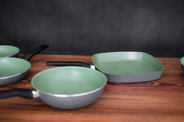 Set of grill pans on wooden table background