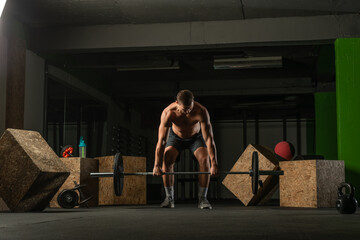 Fit strong shirtless athlete doing squats. Hardcore Cross-fit workout concept.