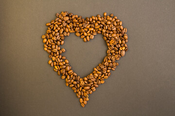 Top view of heart made of coffee beans on the dark background