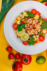 healthy food, salad with shrimps and vegetables with rice on a decorated table