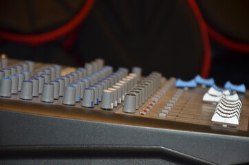 Professional audio mixing console with faders and adjusting knobs