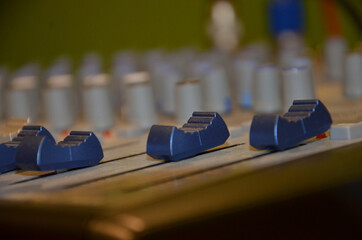 Professional audio mixing console with faders and adjusting knobs
