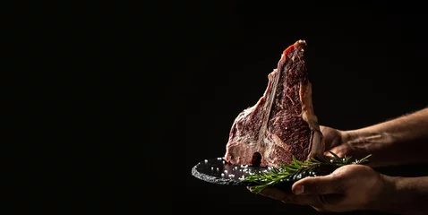  Cook hands with big raw T-bone or aged wagyu porterhouse grilled beef steak with spices Ready to Cook. Restaurant menu, dieting, cookbook recipe. Long banner format © Надія Коваль