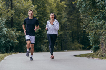 Naklejka premium Athletic couple running on a street next to each other. Nature,fit and healthy concept.