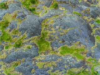 Aerial view on old granite rocks covered with grass, moss and lichen