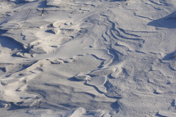 Snow texture with grass and shadows in sunny morning