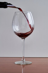 red wine is poured into a glass
