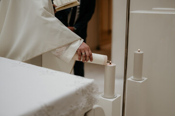 Church minister lighting a candle from another candle during a ceremony