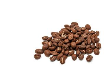 Mostly a scattered pile of roasted coffee beans close-up on a white background. Copy space