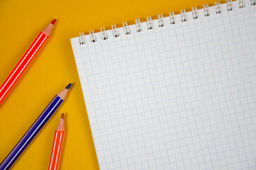 Colored pencils and notepad on wooden table