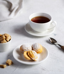 Homemade cookies, a cup of tea and sugar on a light table.