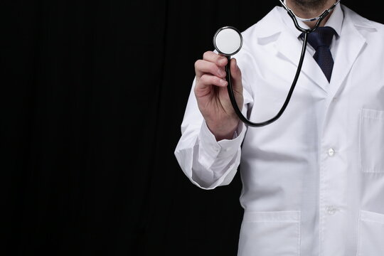 Doctor with stethoscope on black background