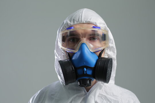 Man in protective suit goggles and respirator