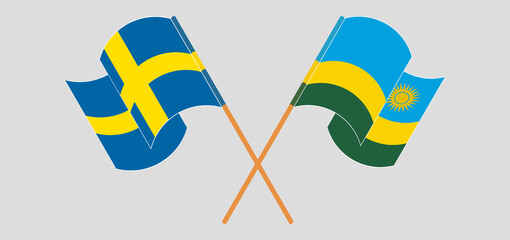 Crossed and waving flags of Sweden and Rwanda
