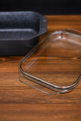 black casserole with a glass cover for baking isolated on wooden background