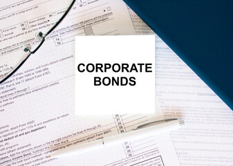Obraz premium Tax form with business card with text Corporate Bonds. Notepad, eyeglasses and white pen
