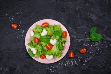 Fresh mx salad with tomatoes and heart shaped mozzarella cheese. Valentines day food. Copy space