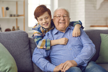Portrait of happy old grandfather with grandson smiling and looking at camera. Senior man enjoys...