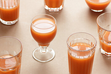 Minimalist monochrome geometric abstract arrangement of  vintage glasses with orange carrot juice on beige and brown background, isometric design pattern copy space, abstract modern art design concept
