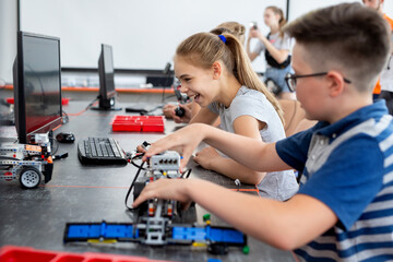 School children programs a robot in the classroom