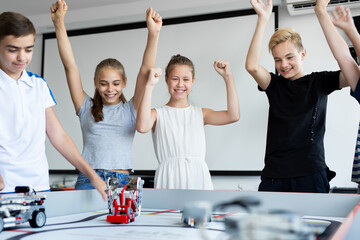 Children in robotics classes celebrate victory